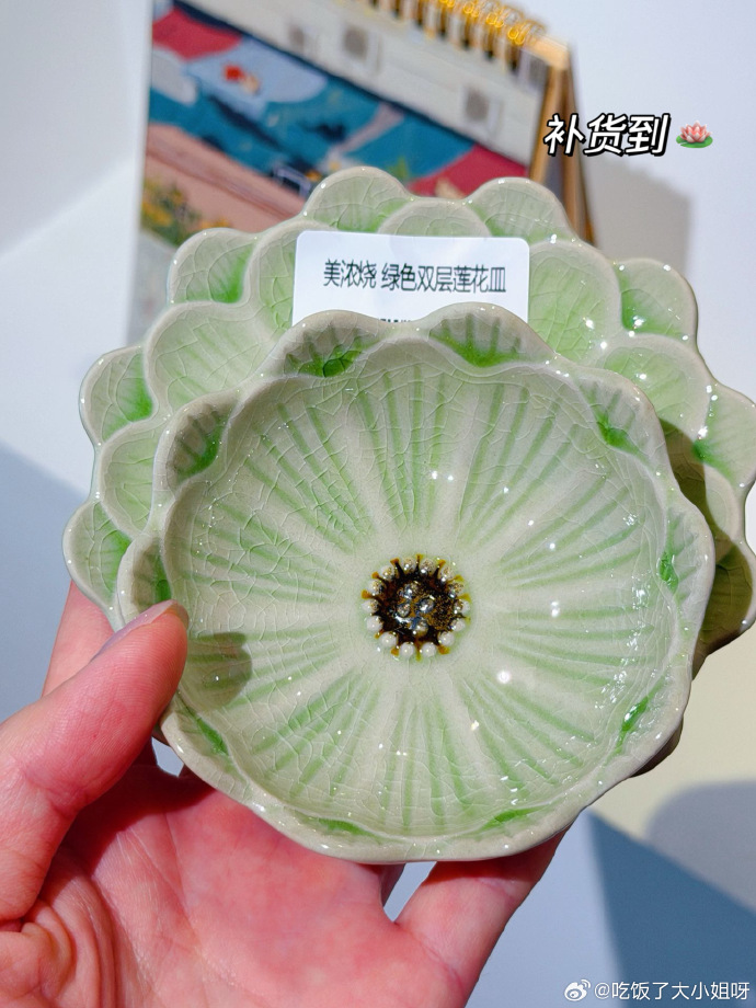 手中托着两只浅绿色莲花形小皿