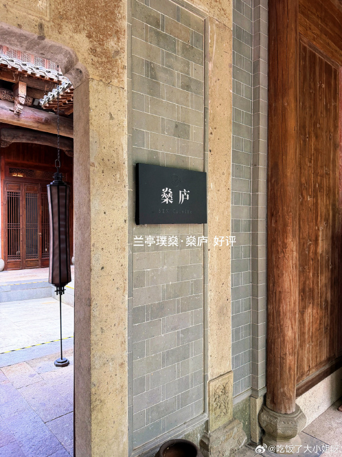 老建筑木门旁的餐厅名牌