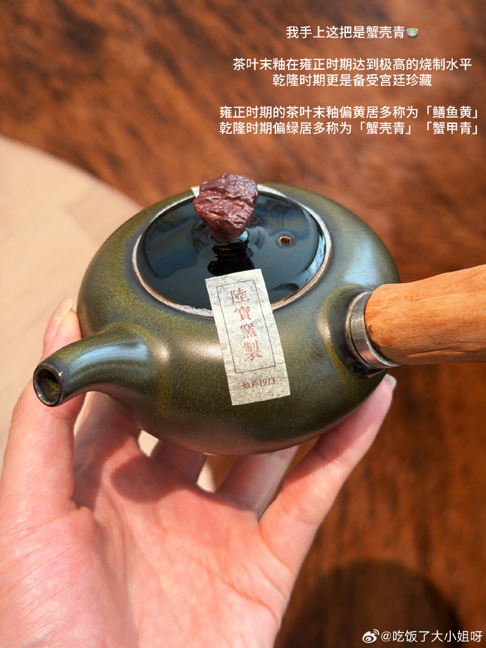 手中托着温润青绿色的茶叶末釉茶壶